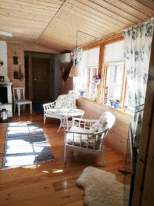 salon z białymi krzesłami i stołem w obiekcie House with lake plot and own jetty on Skansholmen outside Nykoping w Nyköping
