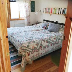 a bedroom with a bed with a quilt on it at House with lake plot and own jetty on Skansholmen outside Nykoping in Nyköping