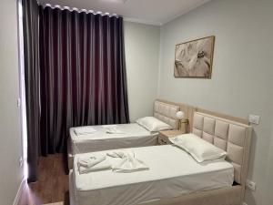 a hotel room with two beds and a window at Hotel Dollari in Durrës