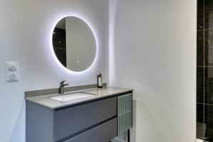 La salle de bains est pourvue d'un lavabo et d'un miroir. dans l'établissement Yann : Détente et Confort près de Rouen, à Sotteville-lès-Rouen