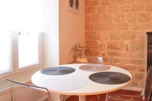 una mesa blanca con 4 sillas y una pared de ladrillo en Beautiful apartment near the Canal de l'Ourcq en París