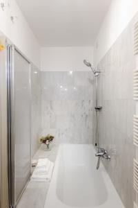 a white bathroom with a shower and a tub at Georgia Modern Panoramic Penthouse with Elevator in Lucca +23 photos