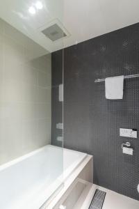La salle de bains est pourvue d'une douche et d'une paroi en verre. dans l'établissement Hangetsu Niseko, à Niseko