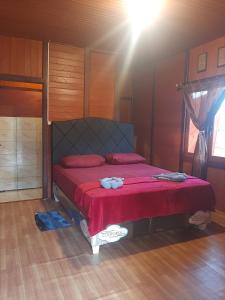 um quarto com uma cama com um cobertor vermelho em Blue Shark Divers Bunaken em Bunaken