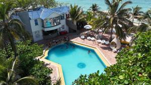 einen Luftblick auf einen Pool vor einem Haus in der Unterkunft Hotel Tropical Inn in Tierra Bomba