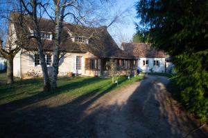 a large white house with a tree and a dirt road at Sur la route de Chambord in Muides-sur-Loire