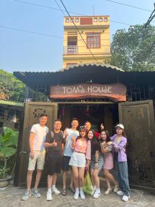 un groupe de personnes debout devant une maison dans l'établissement Tom's house motorbikes tour and homestay, à Làng Me