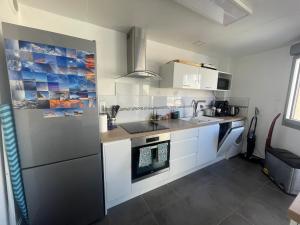 cocina con fregadero y nevera en Appartement 40m2 - Bord de mer en Frontignan