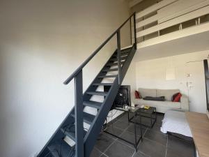 - un salon avec un escalier et un canapé dans l'établissement Appartement 40m2 - Bord de mer, à Frontignan