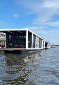 ein Gebäude auf einem Boot auf dem Wasser in der Unterkunft Houseboat EnergyApart in Stettin