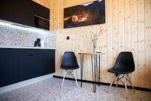 a kitchen with two black chairs and a table at Koliberek Apartament SPA in Szalejów Górny