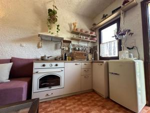 a small kitchen with a stove and a refrigerator at Aristea's House in Arkalochori