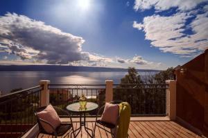 a balcony with a table and chairs and a view of the water at Two houses Villa Diana Jesenice with pool, sauna, playground in Jesenice
