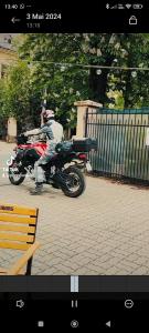 a man riding a motorcycle down a street at Pensiunea Buon Gusto Sibiu-motorcyle friendly,city center in Sibiu