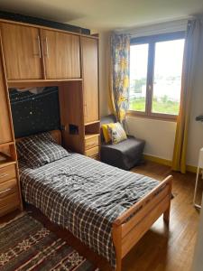 Un dormitorio con una cama y una silla y una ventana. en Pavillon F4, en Thiais 36 fotos más