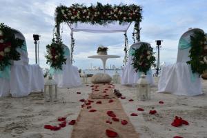 a wedding ceremony on the beach with roses on the sand at Hotel Tropical Inn in Tierra Bomba