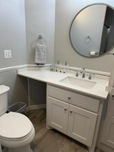 a bathroom with a sink and a toilet and a mirror at Amys Place Remolded 4 Bedroom near Arkansas Tech in Russellville