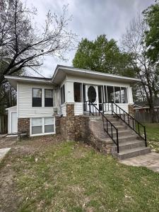a white house with a porch and stairs at Amys Place Remolded 4 Bedroom near Arkansas Tech in Russellville
