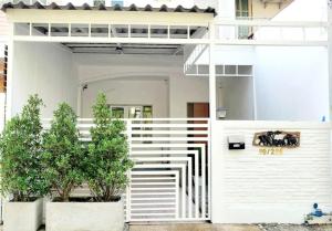 a white house with a white fence and some plants at บ้านสวัสดี Bann Sawasdee in Ban Sai Mai