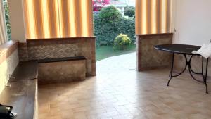 um pátio com uma mesa preta e colunas amarelas em 2 bedrooms house at Calasetta 400 m away from the beach with enclosed garden em Calasetta