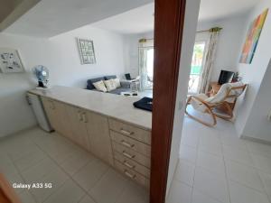 a kitchen with a counter and a living room at Coqueto apart en Las Coronas in Costa Teguise