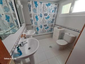 a white bathroom with a toilet and a sink at Coqueto apart en Las Coronas in Costa Teguise