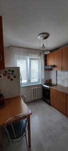 a kitchen with a refrigerator and a table in it at Квартира у реки in Rīga