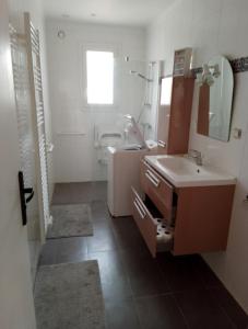 a bathroom with a sink and a mirror at Spacious and cosy 80 m house located in Séné in Séné