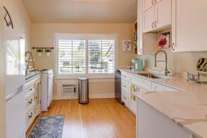a kitchen with white cabinets and a sink and a window at Walk to Courthouse Square Quiet Home with Porch in Prescott