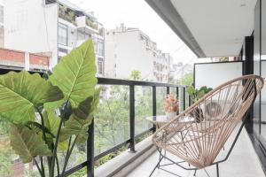 Un balcón con una silla y una planta en Fliphaus Zapiola 2300 - Lux Aparts 'a' Belgrano en Buenos Aires