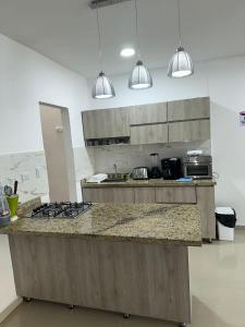 eine Küche mit einer Theke und einem Kochfeld in der Unterkunft Espectacular apartamento central in Montería