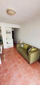 a living room with a green couch in a room at Apartamento Fuengirola Centro in Fuengirola