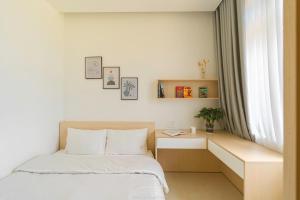 1 dormitorio con 1 cama, escritorio y ventana en Lucia House, en Ấp Kim Thạch