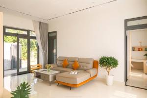 a living room with a couch and a table at Lucia House in Ấp Kim Thạch