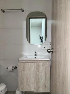 y baño con lavabo y espejo. en Espectacular apartamento central en Montería