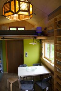 a dining room in a tiny house with a table and chairs at Les Jours Heureux Tiny House in Villers-le-Gambon