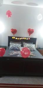 een slaapkamer met een bed met rode harten aan de muur bij hotel khaouni bourdj bou arraredj in Bordj Bou Arreridj