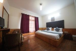 a bedroom with a large bed and a window at Ramta Jogi Hotel & Stays in Manāli