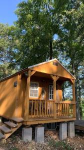 eine große Holzhütte mit einer Veranda und Bäumen in der Unterkunft Valley View Cabin - Buffalo Point in Maumee