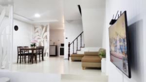a living room with a table and a dining room at Bann Sawasdee Donmueng- Saimai หลังใหญ่ ฟรี wifi in Ban Sai Mai