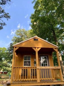 a large wooden cabin with a porch and two windows at Valley View Cabin - Buffalo Point in Maumee