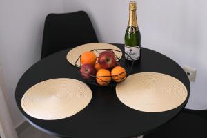 a table with a bowl of fruit and a bottle of champagne at DUOMO City Center Suites, 1st Floor in Heraklio Town +20 photos