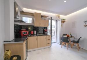a kitchen with wooden cabinets and a table with chairs at DUOMO City Center Suites, 1st Floor in Heraklio Town