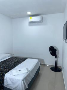 a bedroom with a bed and a fan and a television at Espectacular apartamento central in Montería