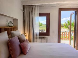 Schlafzimmer mit einem großen weißen Bett und einem Fenster in der Unterkunft Bed & Breakfast Wine & Cooking Penedès in Pla del Panadés