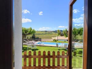 uma vista para uma piscina a partir de uma porta em Bed & Breakfast Wine & Cooking Penedès em Pla del Panadés