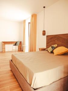 a bedroom with a large bed and a desk at U Zuccareddu in Alcamo