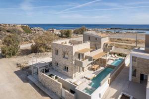 an aerial view of a building with the ocean in the background at Pietra Di Sabbia Villas in Palaiochora