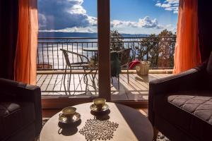 a living room with a view of a balcony at Two houses Villa Diana Jesenice with pool, sauna, playground in Jesenice