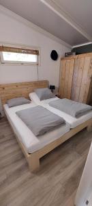 two large beds in a room with wooden floors at Casa 2234 op camping de Schatberg in Sevenum +20 photos